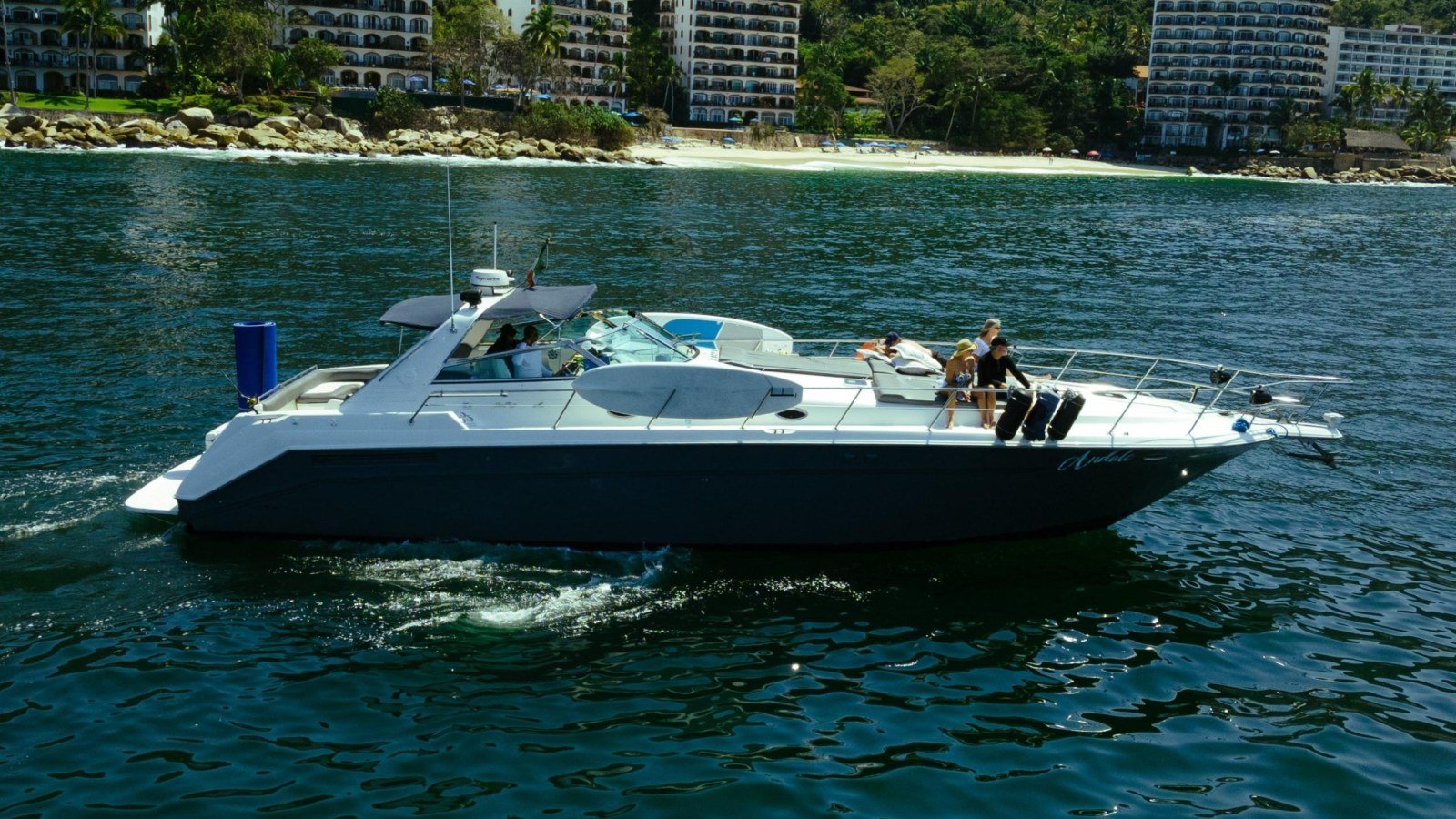 Un yate Sea Ray 50 navegando frente a los cerros verdes de la costa sur de Puerto Vallarta en un charter privado